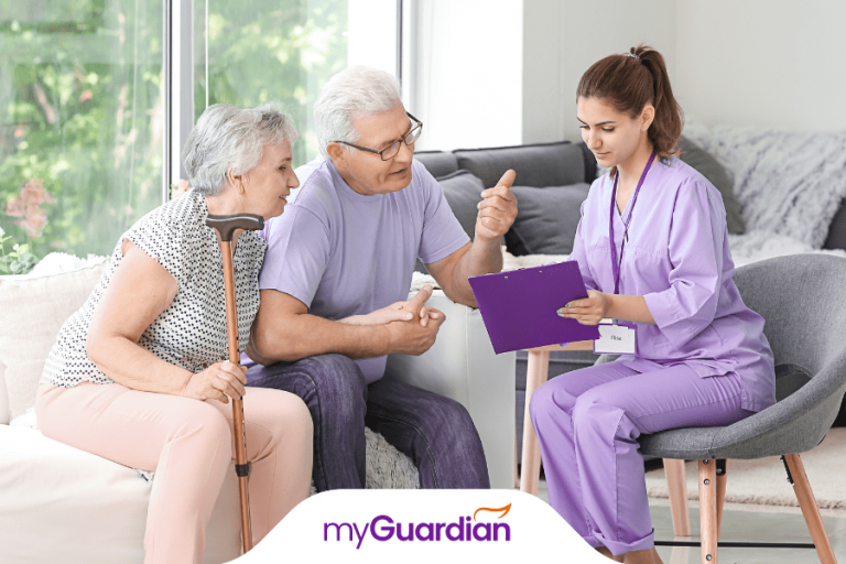 A female caregiver is consulting with two elderly individuals about available aged care services